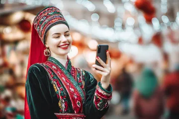 A man celebrating a winning moment on his laptop while gaming symbols float around him, capturing the excitement of BB444 games.